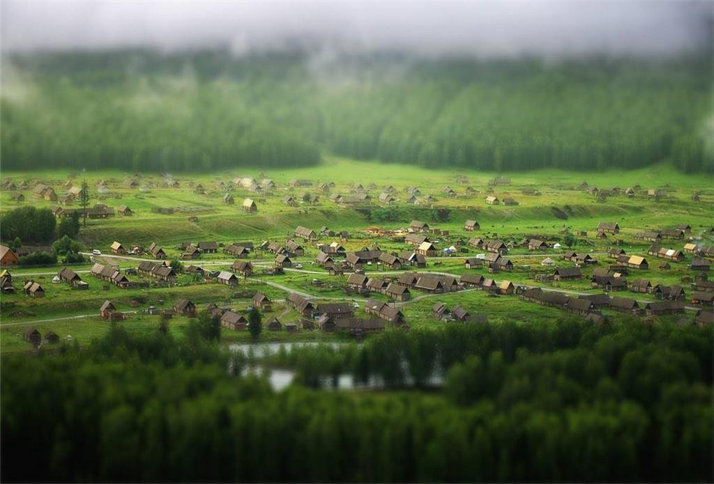 A still reed-fringed river channel at blue hour with mist rising over the water in Altai